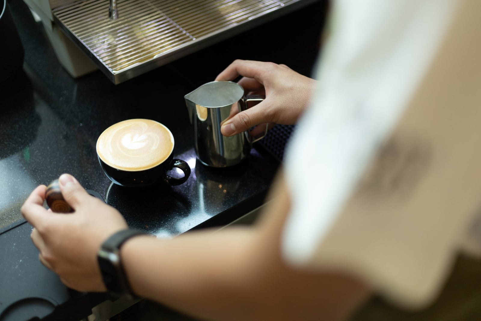 Barista pouring a latte at Parry Road Café, Cormar Suites